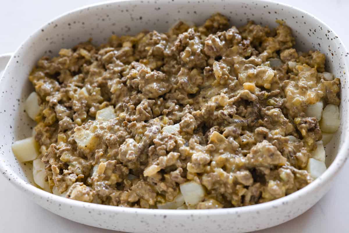 Meaty, cheesy, and chock full of tasty mix-ins like hash browns, pickles, and onions, Big Mac casserole is the perfect dinner to make this week! It’s an easy, deconstructed version of the classic burger we all know and love. The meat layer being added.