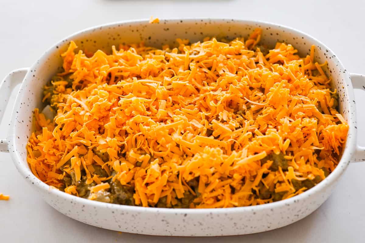 Meaty, cheesy, and chock full of tasty mix-ins like hash browns, pickles, and onions, Big Mac casserole is the perfect dinner to make this week! It’s an easy, deconstructed version of the classic burger we all know and love. Sprinkling shredded cheese on the Big Mac casserole.