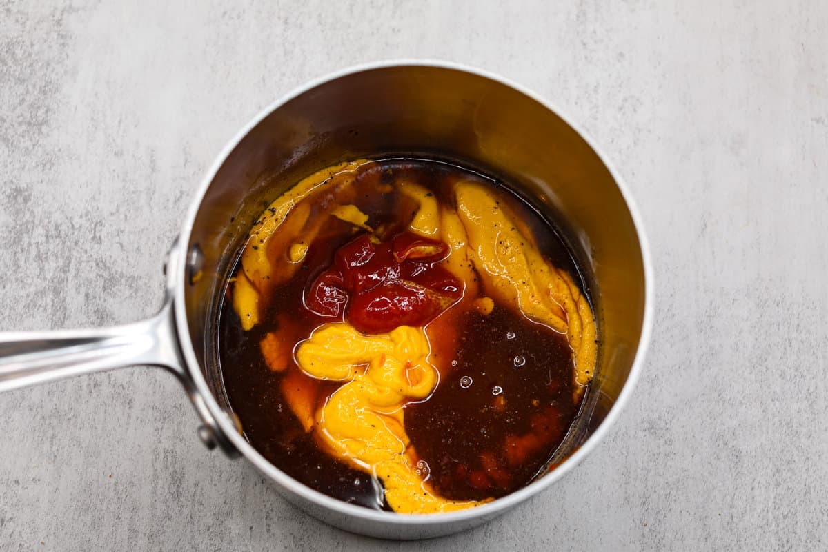 Smoky, tangy, and sweet, your taste buds will be begging you for more of this Mustard BBQ Sauce! It's the perfect addition to your summer cookouts this year, adding the best flavor to grilled meats! Adding all of the ingredients to a saucepan.