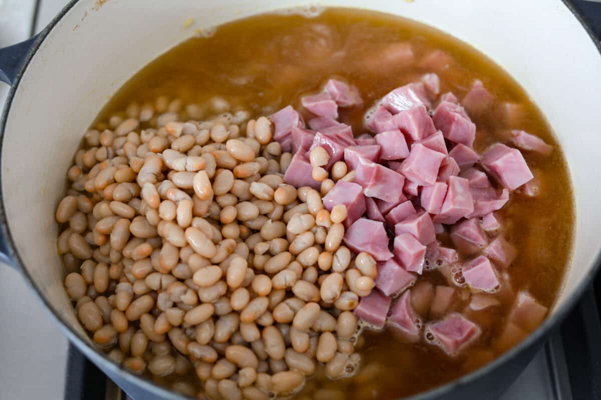 Third process photo of the beans and ham added to the pot.