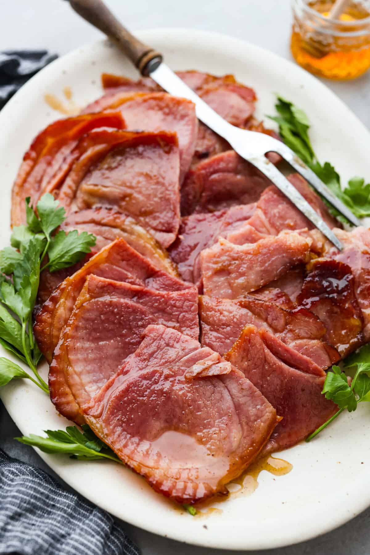 A honey glazed ham, cut into slices.