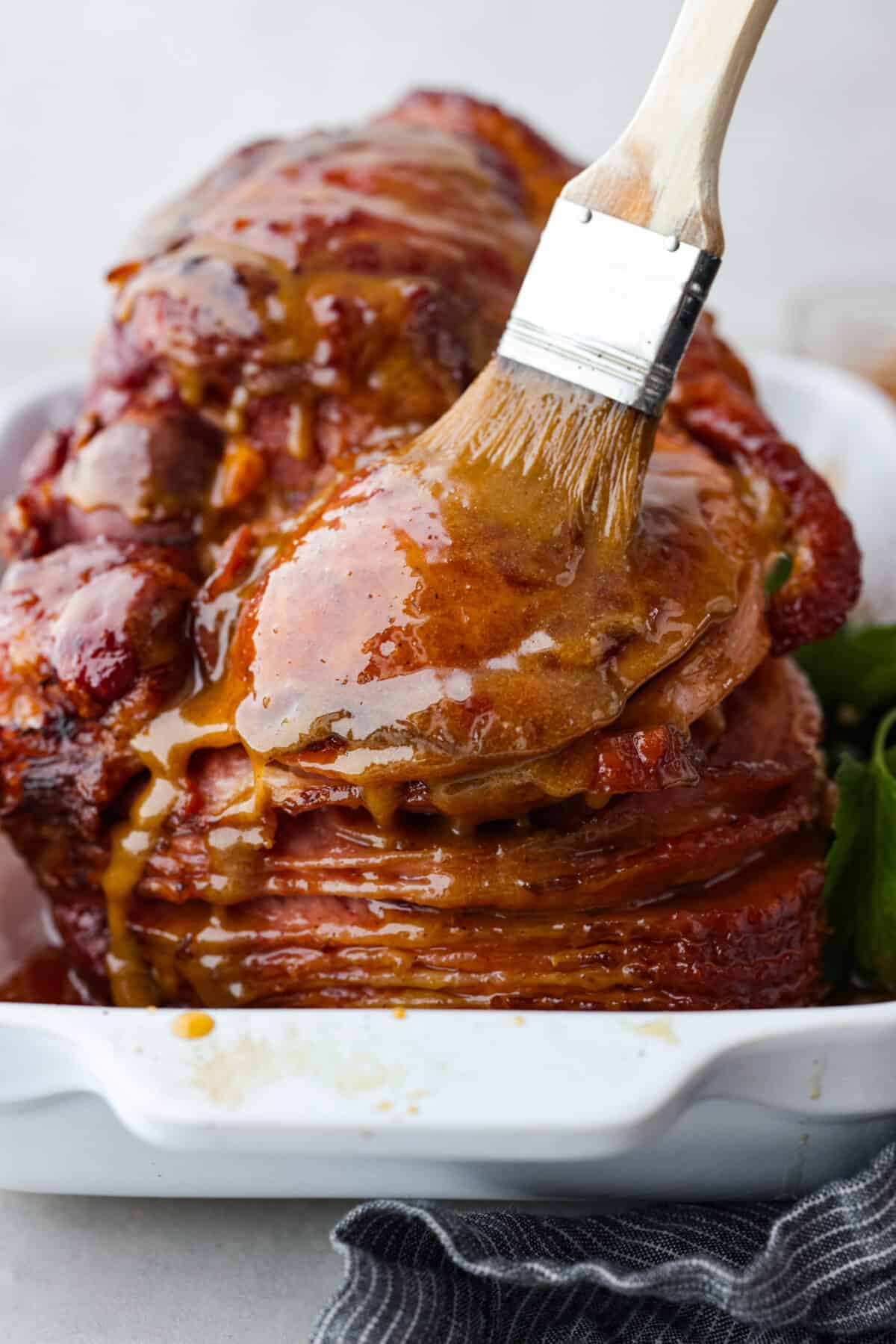 Honey glazed ham being basted with extras of the honey brown sugar mixture.