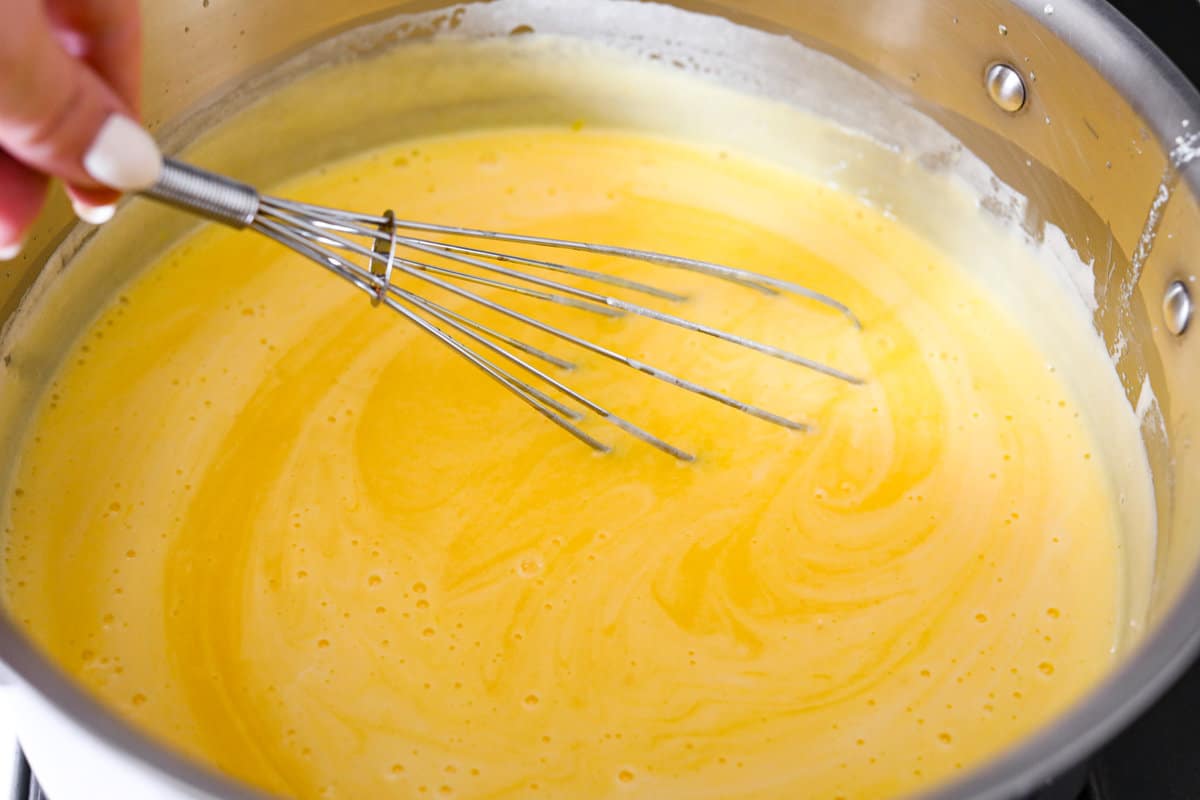Meet lemon tiramisu! The most amazing citrusy twist on a classic Italian dessert. The layers of mascarpone cream and lemon curd will have you reaching for another slice! Whisking the egg mixture together.