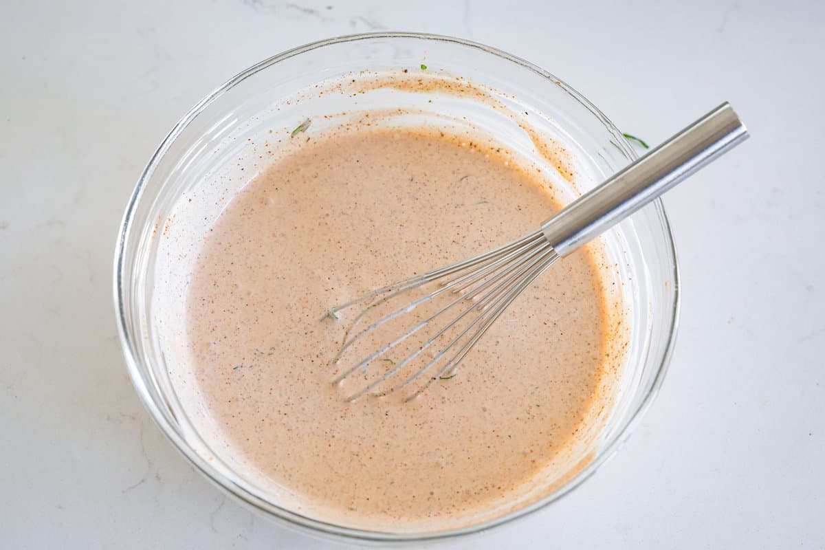 This creamy Southwest dressing is packed with zesty lime and bold spices, ready to upgrade your favorite bowl of greens! It takes less than 10 minutes and only a few pantry staples to make. Whisking up the dressing.
