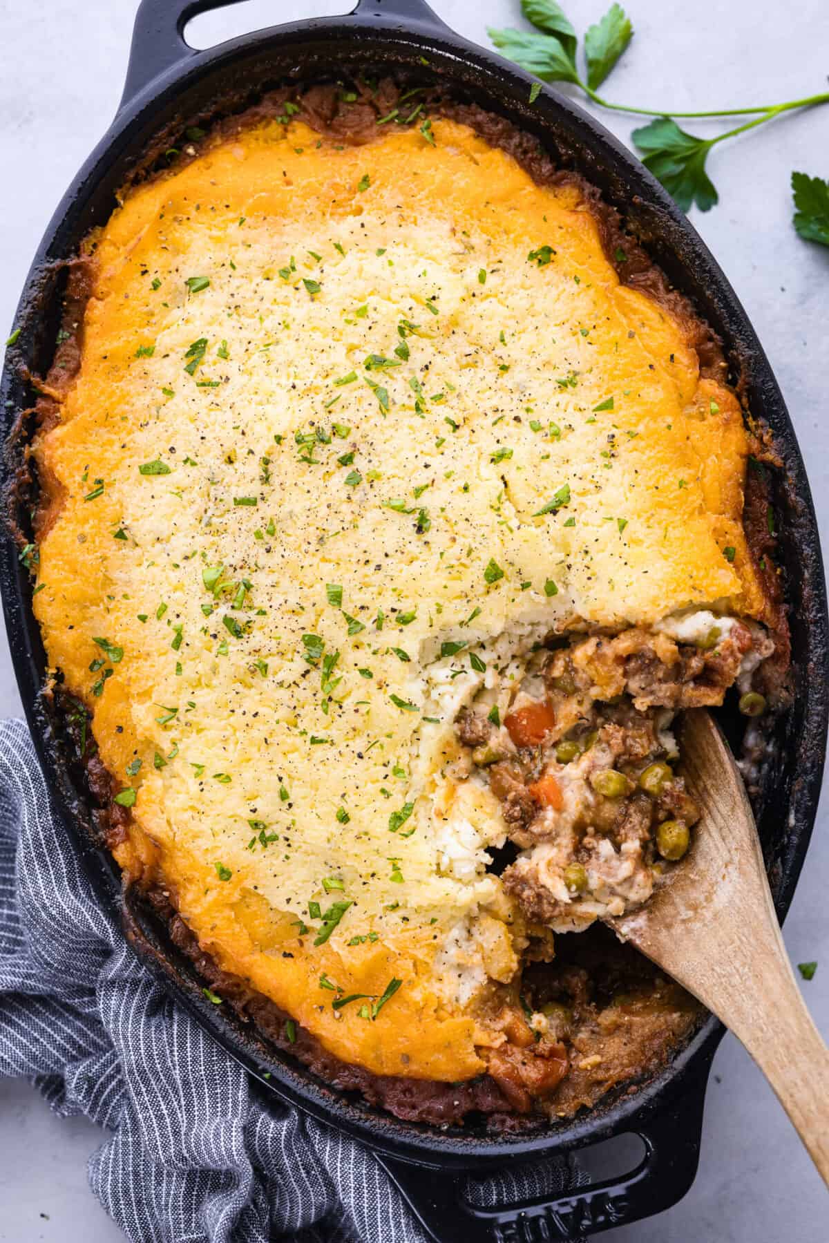Top-down view of shepherd's pie in a baking dish with a scoop taken out of it.