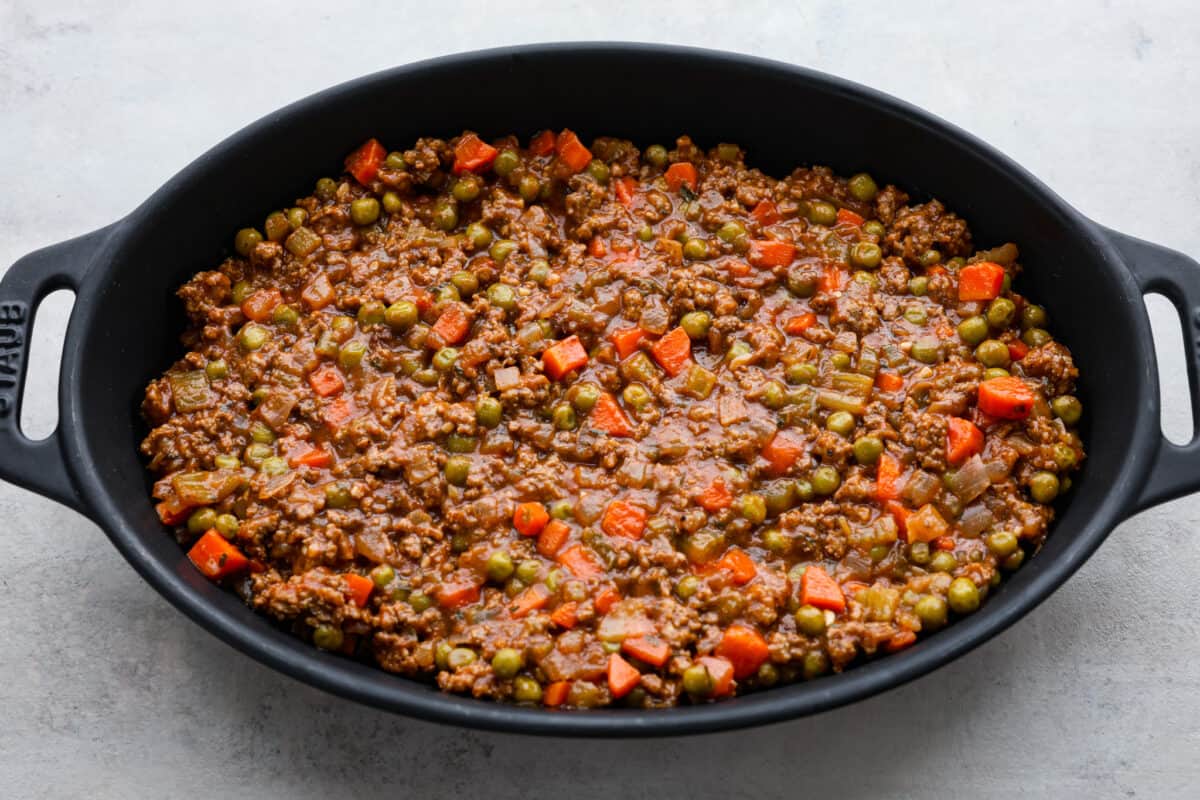 Adding the Shepherd’s pie filling to a baking dish.