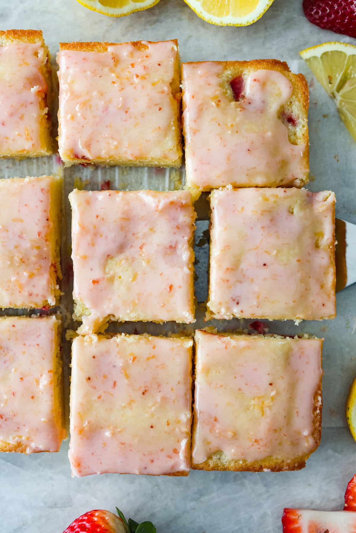 Tender and moist, strawberry lemon blondies are loaded with plenty of sweet, juicy strawberries that are joined with just enough tangy lemon flavor. These amazing bars are buttery, thick and the perfect spring and summer dessert! Top-down view of strawberry lemon blondies, cut into squares.
