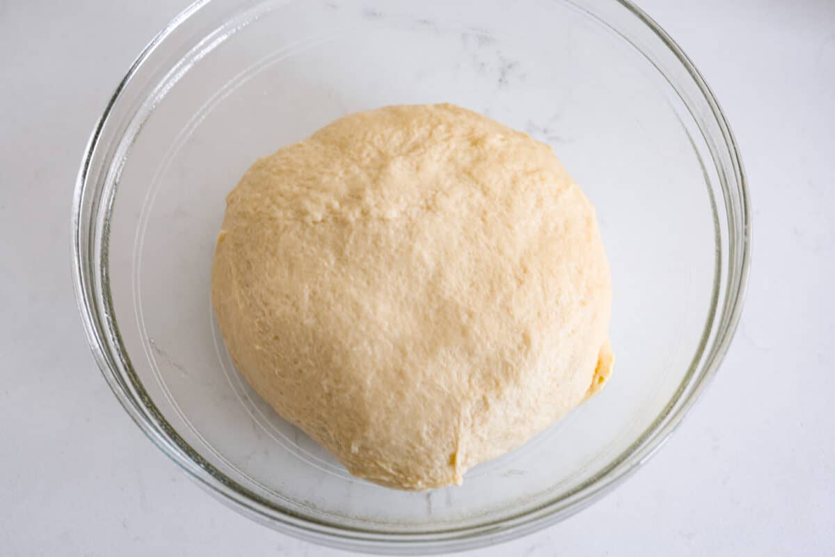 Fifth process photo of the dough rising in a bowl.