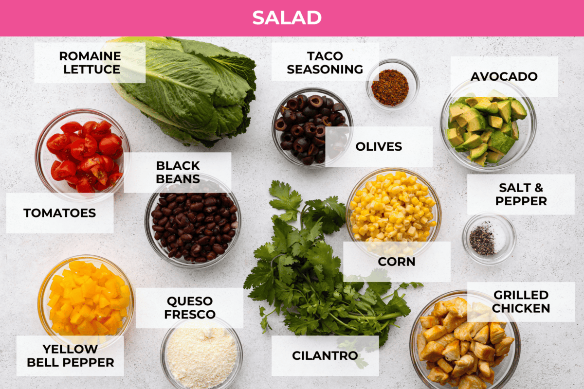All of the salad ingredients prepared in glass bowls.