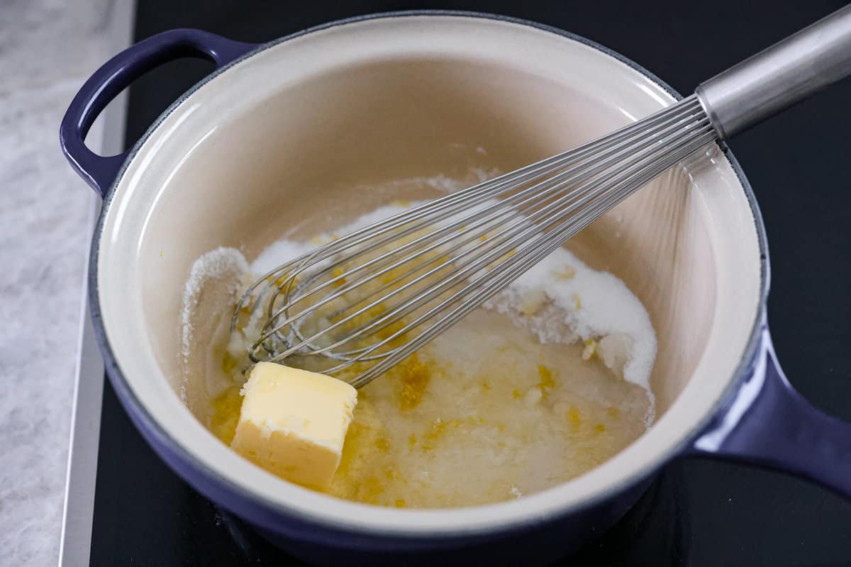 Be prepared to fall in love with this blueberry lemon upside-down cake! A delicious and moist lemon sponge cake bursting with juicy caramelized blueberries on top! First photo of butter, sugar, lemon juice and zest in a saucepan.