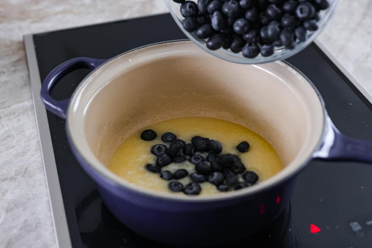 Be prepared to fall in love with this blueberry lemon upside-down cake! A delicious and moist lemon sponge cake bursting with juicy caramelized blueberries on top! Second photo of the blueberries adding to the lemon sauce.