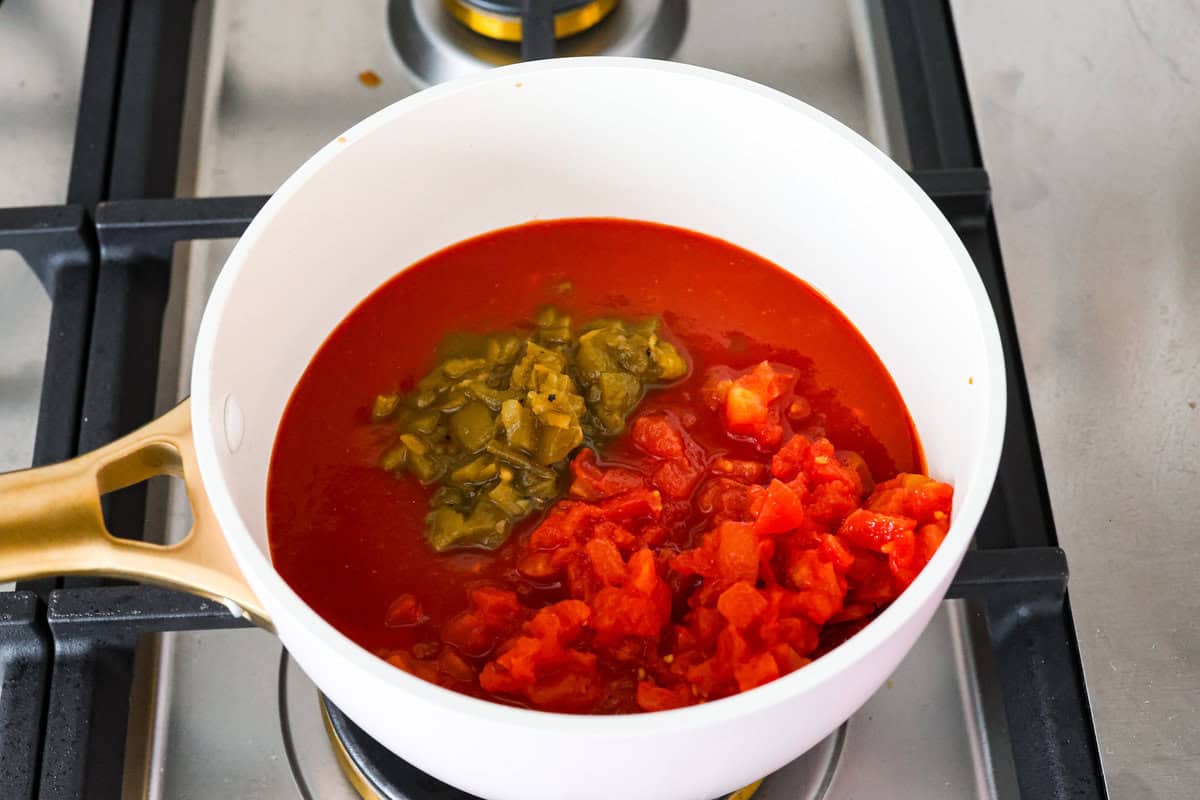 A new enchilada is in town! Get ready for the bold flavors in these buffalo chicken enchiladas! Chicken enchiladas loaded with cheese and smothered in a creamy buffalo enchilada sauce. First photo of the sauce ingredients in a saucepan.