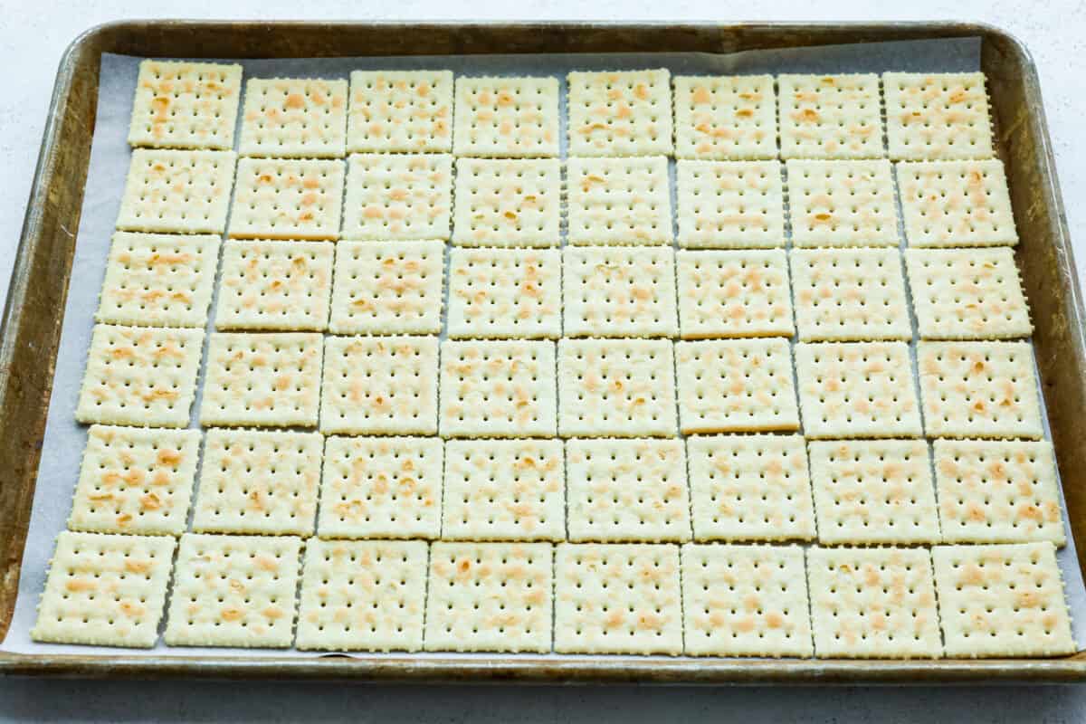 Saltine crackers on a baking sheet. 