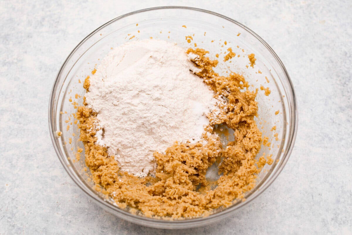 Overhead shot of a bowl with some mixed ingredients and flour. 