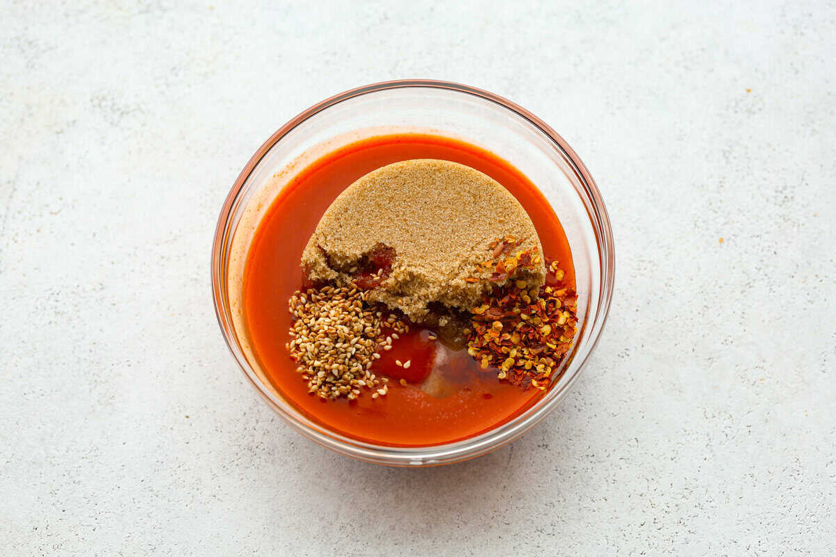 Get ready to spice up your dinner with these firecracker meatballs! Juicy beef meatballs are baked to perfection and then tossed in a sweet and spicy buffalo-based sauce, creating a delicious meal that's perfect for any night of the week. Overhead shot of unmixed sauce ingredients.