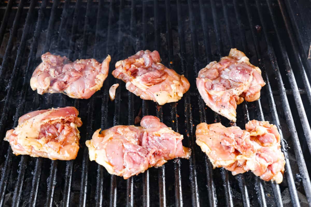 Chicken thighs being marinated on the grill. 