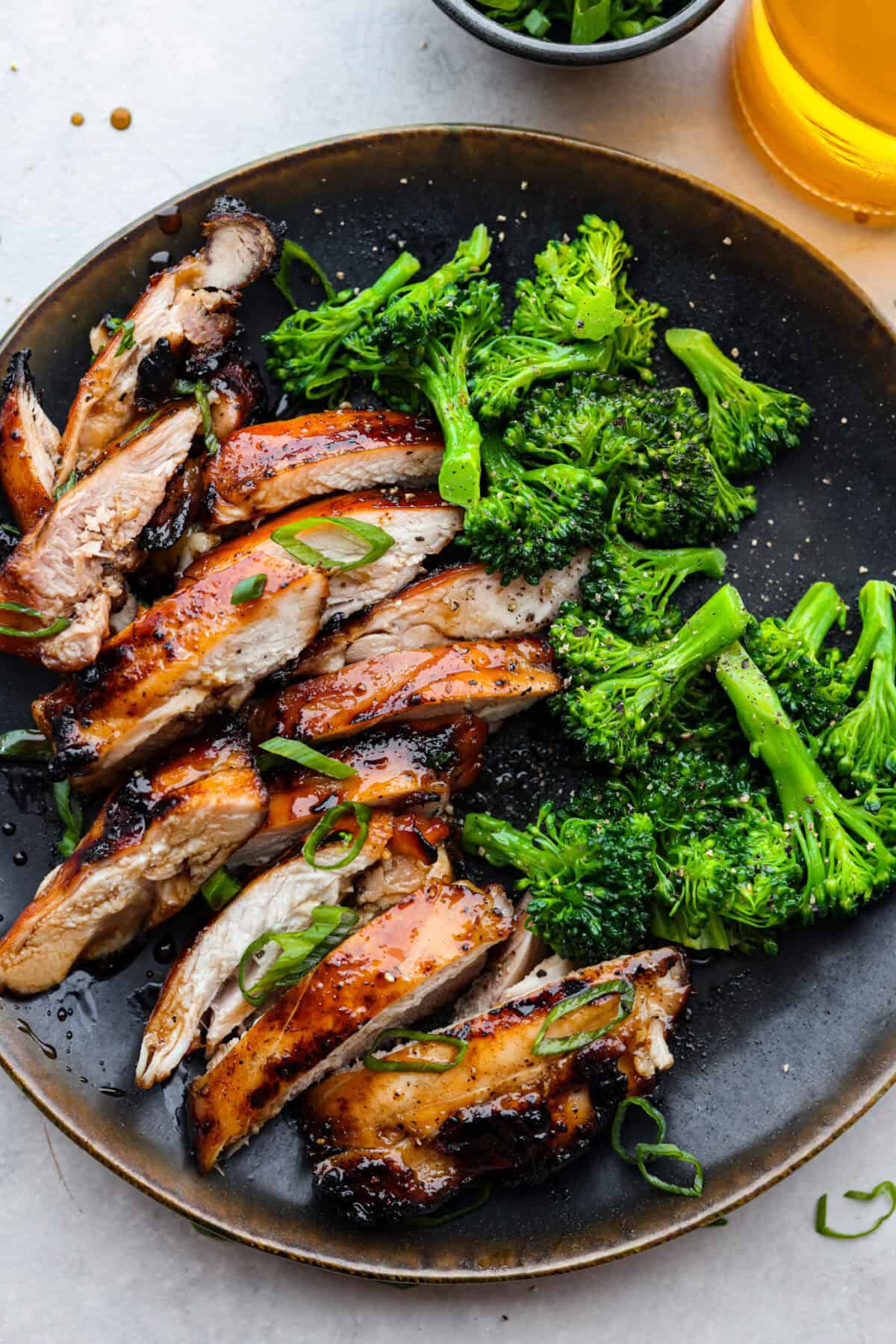 A plate with sliced chicken and broccoli florets. 