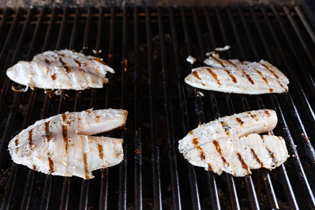 Tilapia flipped on a grill. 