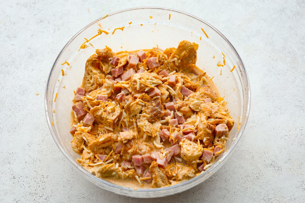 This Ham and Cheese Croissant Casserole is filled with comforting flavors of croissants, eggs, ham and plenty of melty cheese. It's quick and easy to throw together for a yummy dish that works for breakfast, lunch or dinner! The egg mixture combined with the croissants, cheese and ham.