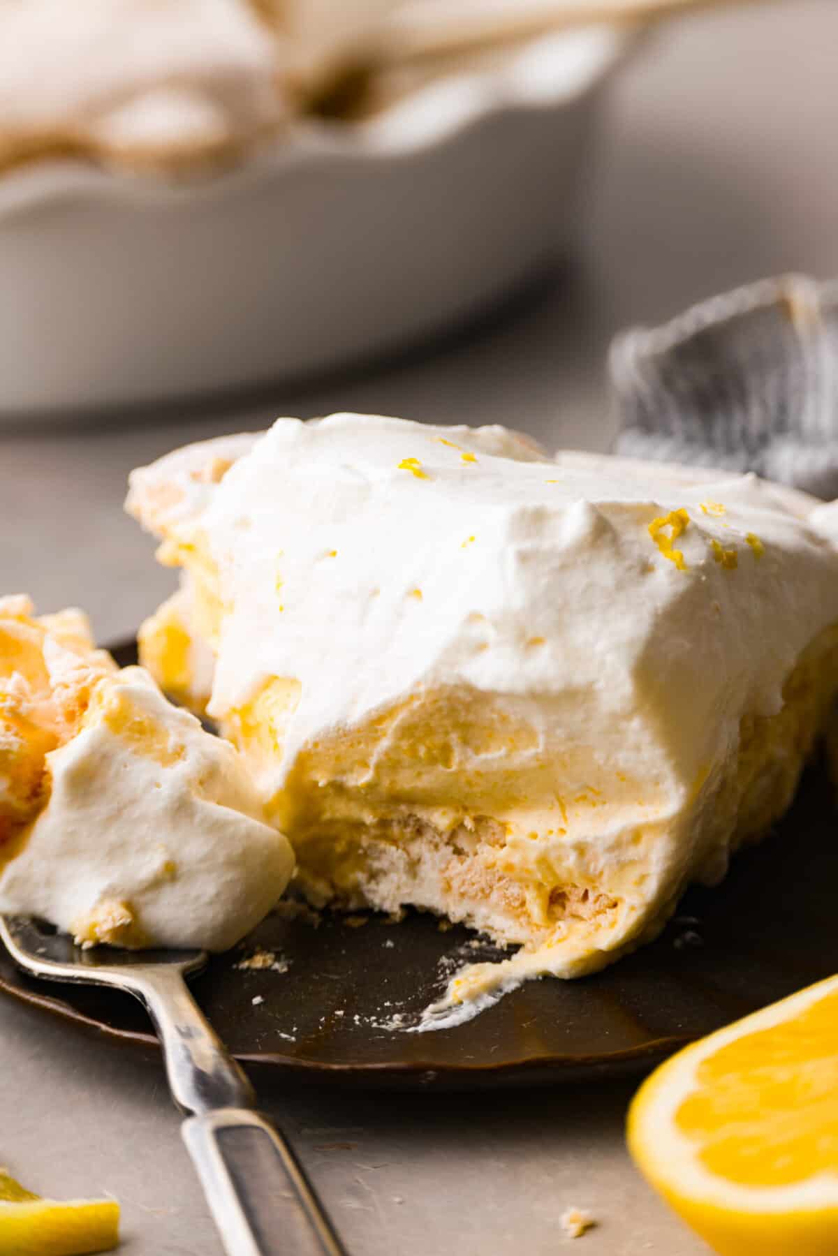 Close view of a slice of lemon pie on a plate with a fork.