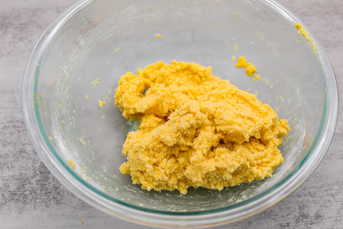 Lemon crinkle cookies are thick, soft pillows of lemon deliciousness! They have a refreshing flavor with an irresistible chewy texture. The perfect balance of sweet and tart make these a welcome treat for any occasion! The finished dough, ready to be covered