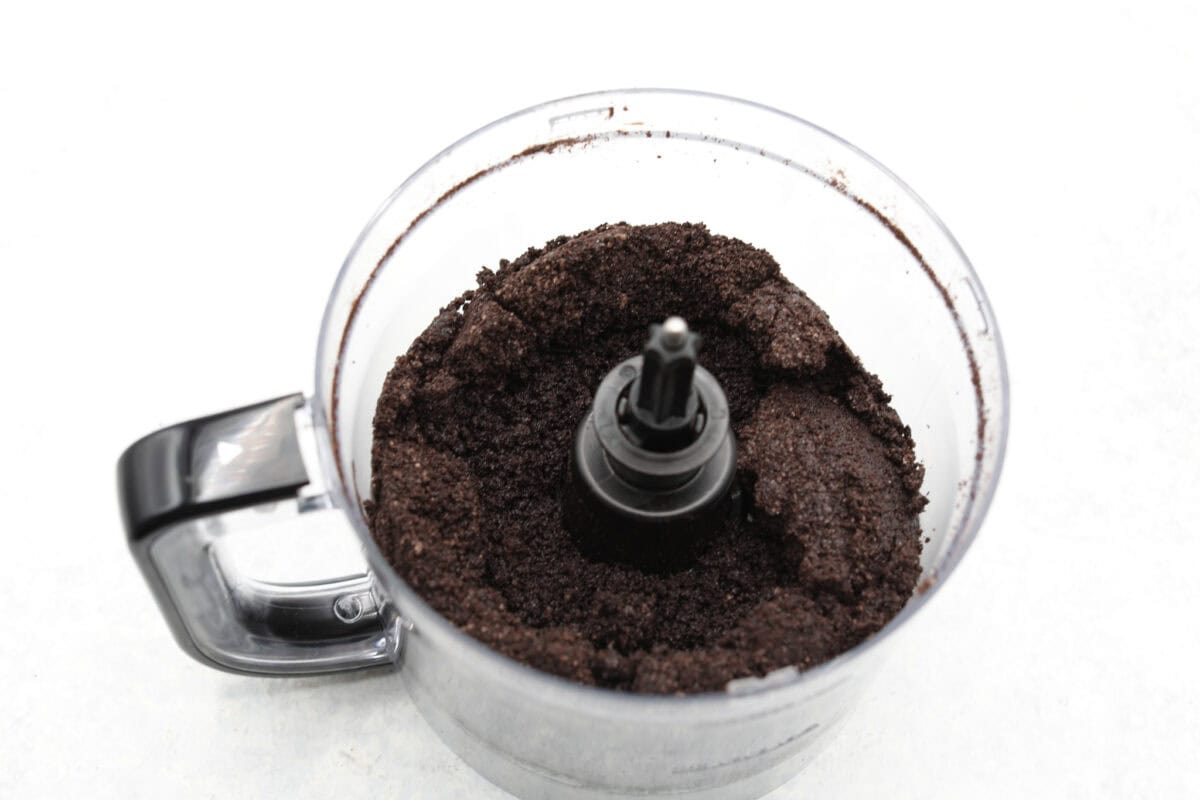 Overhead shot of food processor with crushed Oreos and butter mixed.
