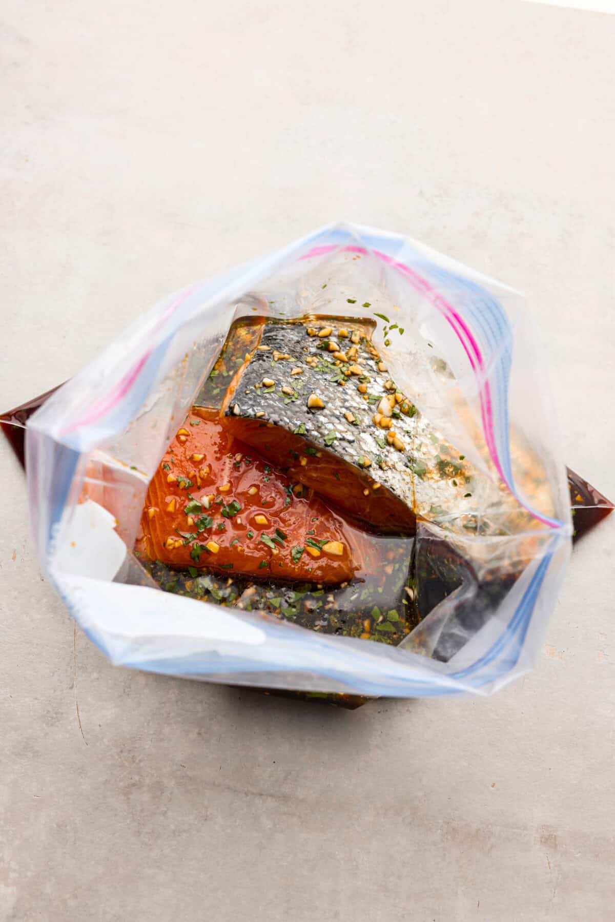 The top view of salmon filets in marinade in a ziplock bag. 