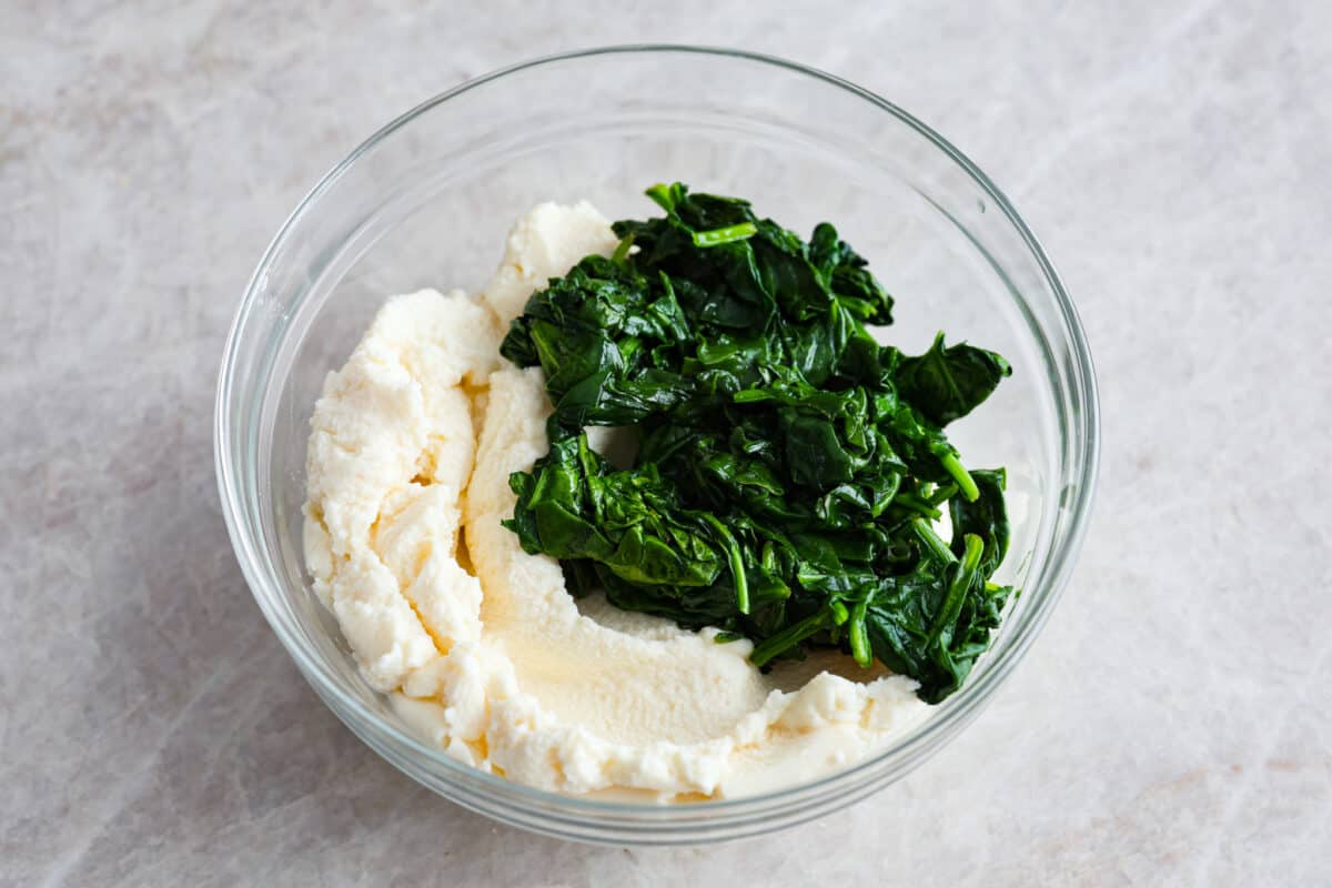 Cooked spinach and ricotta in a glass bowl. 