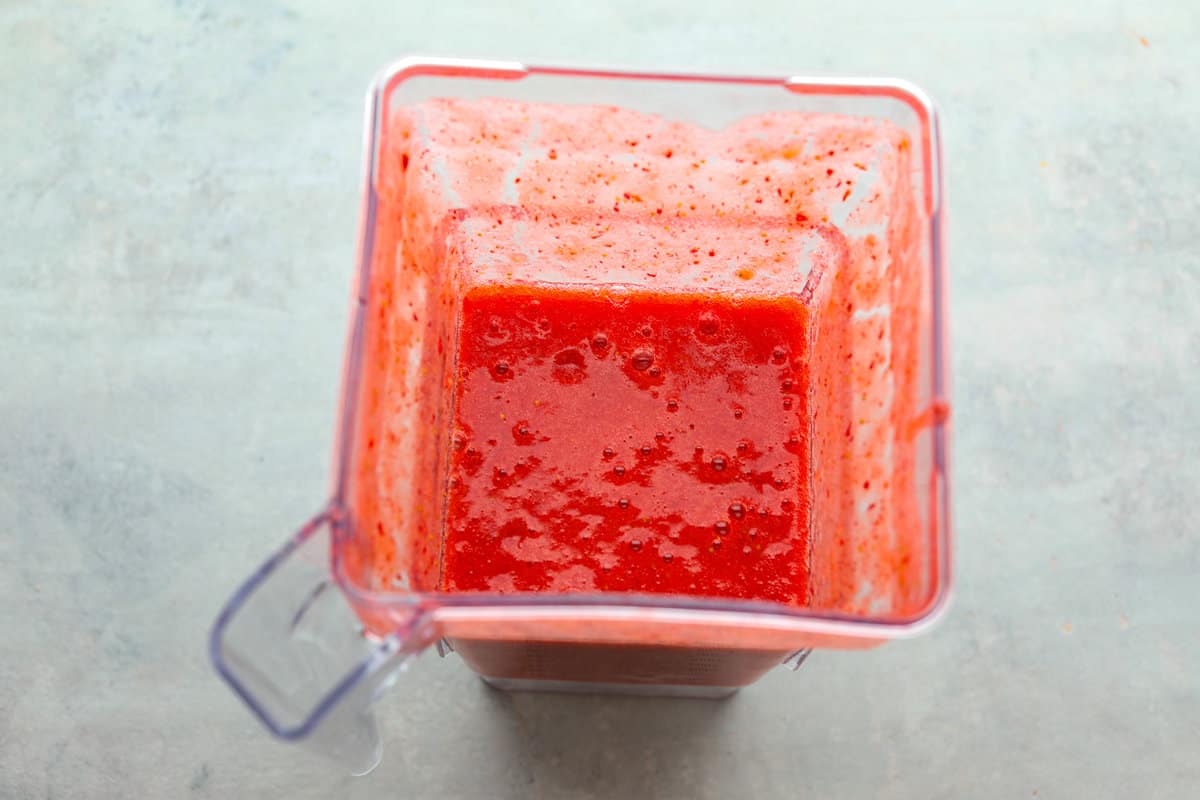 Elevate the flavors of traditional horchata with this strawberry horchata recipe! It's a creamy drink soaked in rice water and cinnamon sticks, then sweetened with a strawberry puree. Everyone loves the strawberry version of this rich, milky Mexican drink! Process photo of the strawberry puree blended in a blender.