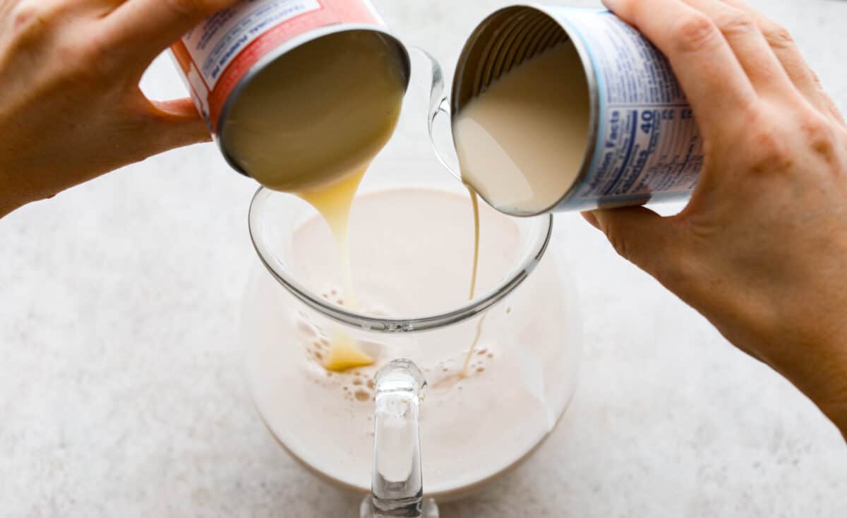 Process photo of the evaporated milk and sweetened condensed milk pouring into the strained rice mixture.