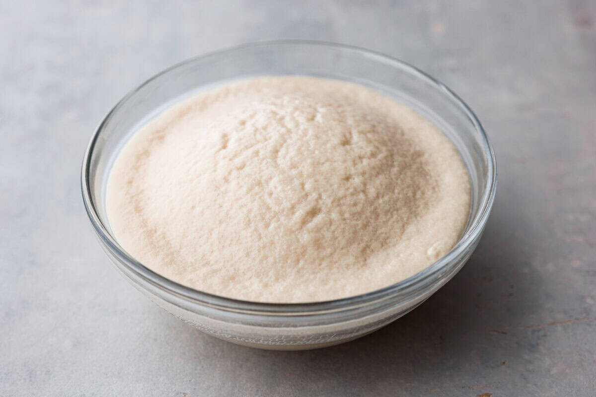 Yeast in a bowl that is not expired and results in a frothy mixture. 