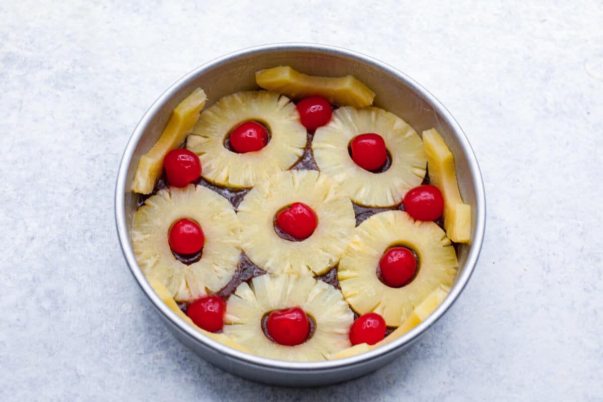 Fourth photo of the pineapple rings and cherries placed on the topping.