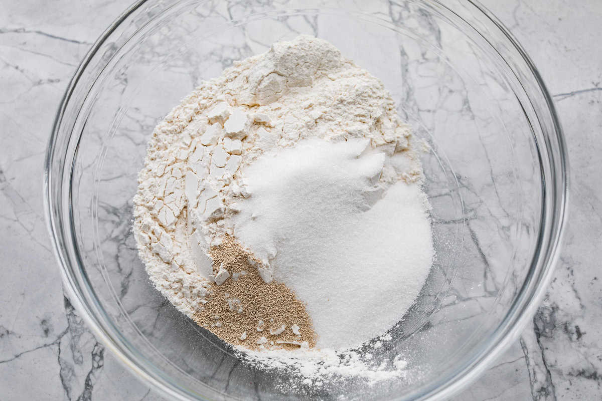 Whip up a batch of these delightful zeppole, perfect for a sweet treat anytime! With a light, fluffy texture and a generous coating of powdered or cinnamon sugar, these Italian donuts are sure to please. Overhead shot of a glass bowl with dry ingredients.
