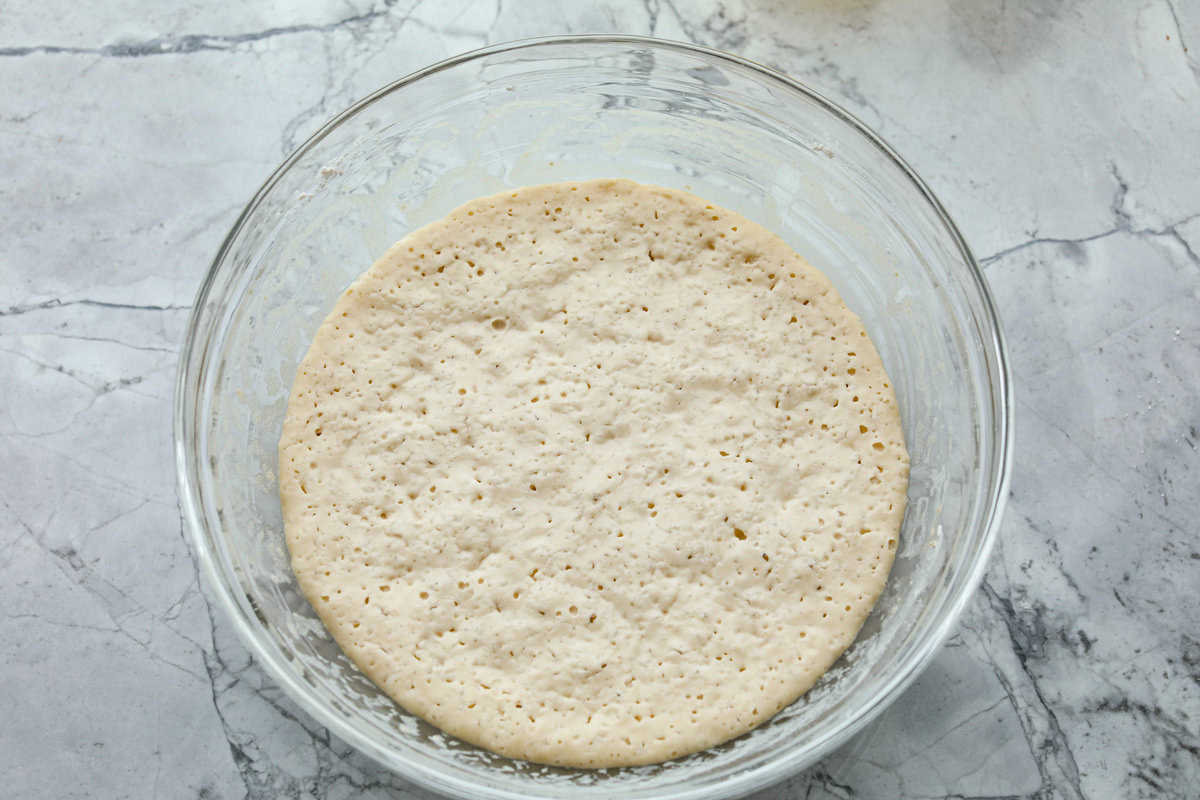 Whip up a batch of these delightful zeppole, perfect for a sweet treat anytime! With a light, fluffy texture and a generous coating of powdered or cinnamon sugar, these Italian donuts are sure to please. Overhead shot of dough resting in glass bowl