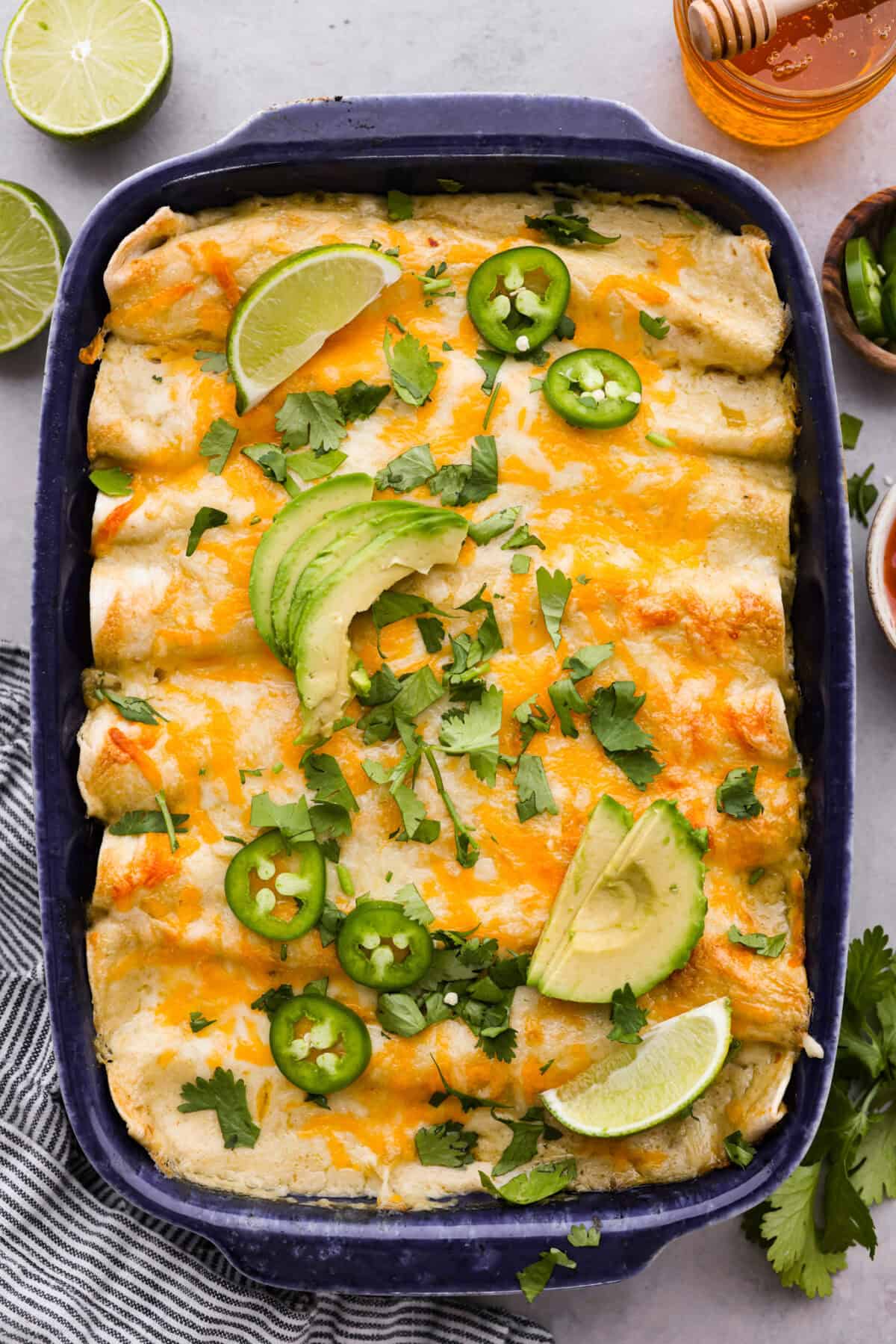 Top view of honey lime chicken enchiladas in a baking dish.