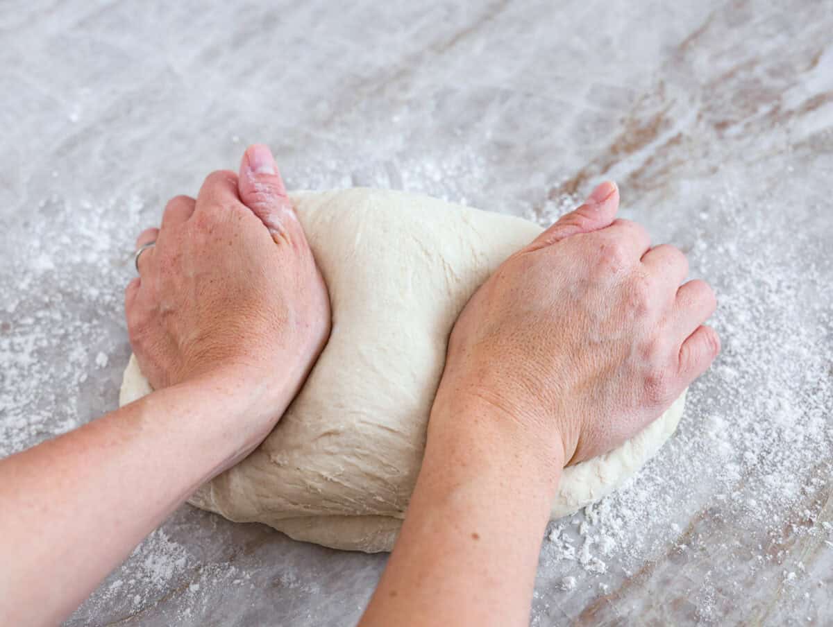 Close view of kneading dough by hand.