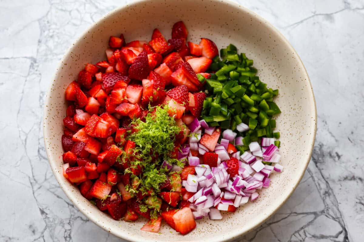 Ingredients for strawberry salsa in a bowl. 