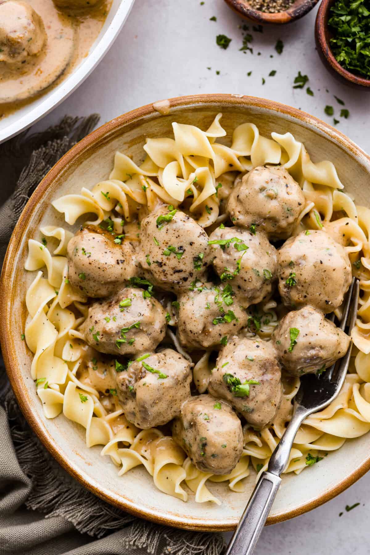 Swedish meatballs on top of egg noodles in a bowl. 