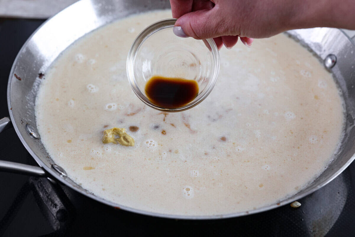Dijon mustard and Worcestershire sauce being added into the Swedish meatball sauce. 