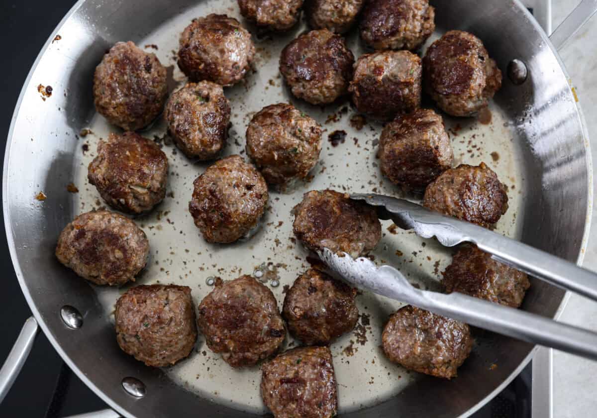 The top view of Swedish meatballs cooking in a pan. 