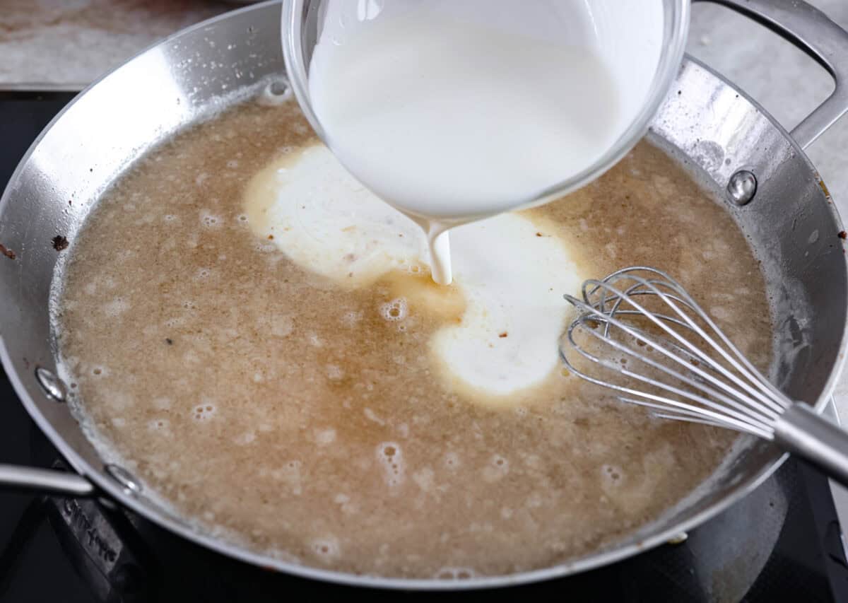 Heavy cream being added into a pan. 