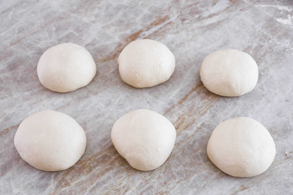 This is the perfect beginner's guide for making wood-fired pizza dough! Pizza expert, Chef Brandon Price, taught me how to make authentic homemade pizza, and now you get to learn too! Second photo of the finished shaped balls of dough.