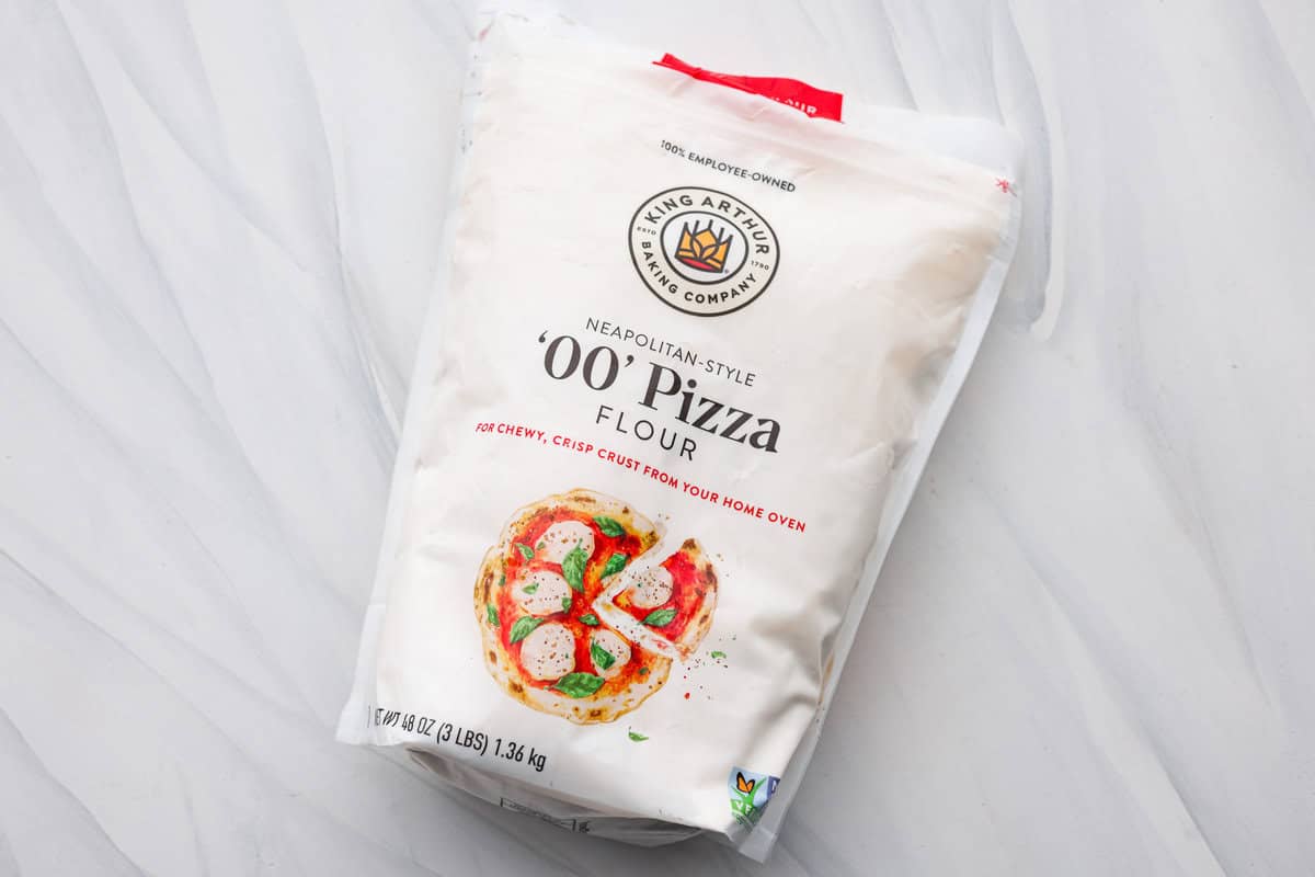 This is the perfect beginner's guide for making wood-fired pizza dough! Pizza expert, Chef Brandon Price, taught me how to make authentic homemade pizza, and now you get to learn too! First photo of '00' pizza flour in the bag.