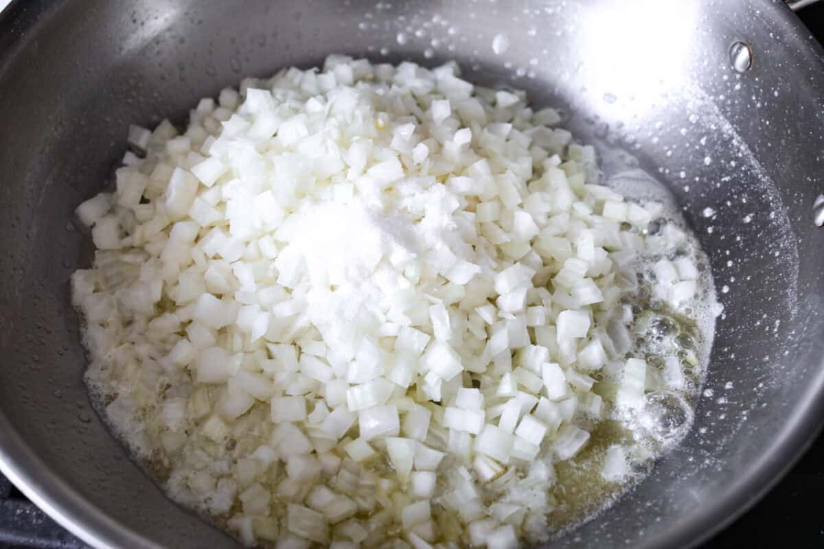 First photo of onions, butter, sugar, and salt in a pan.