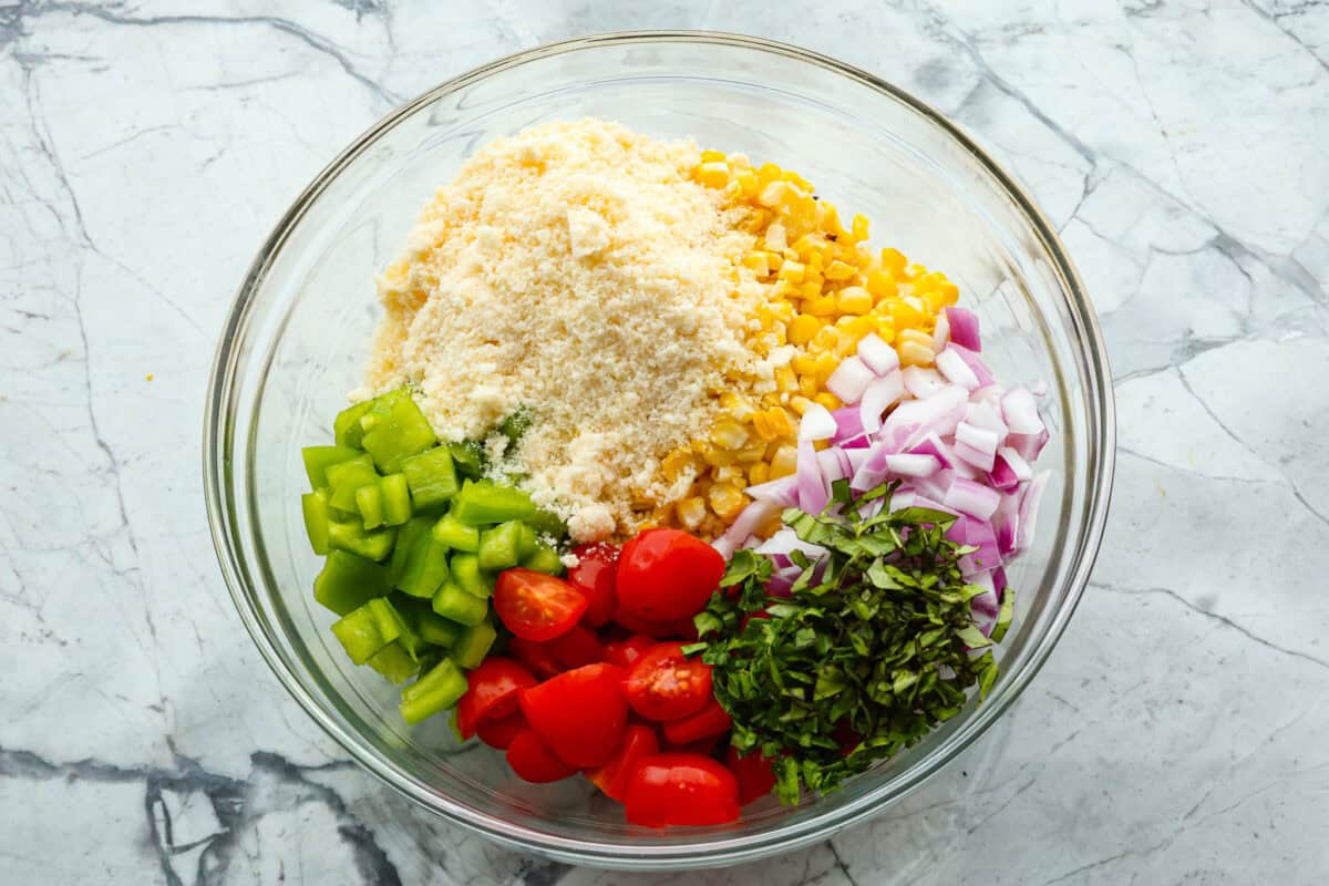 Overhead shot of glass bowl with salad ingredients divided inside of it. 