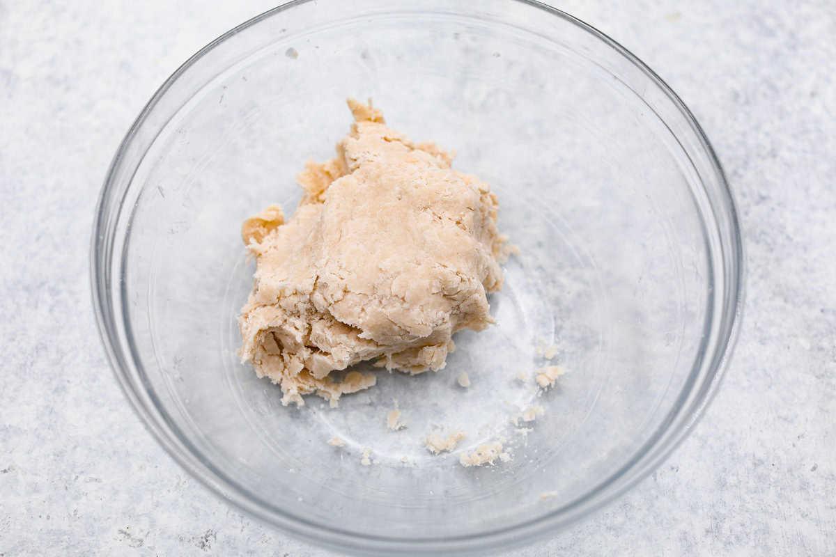 Sugar cream pie, or Hoosier pie, is a creamy, delicious treat with deep roots in the Midwest, especially in Indiana. You can top it however you like, serve it warm, at room temperature, or even chilled. Give this simple recipe a go. I know you’ll love it! Overhead shot of crust dough in a ball in a bowl.
