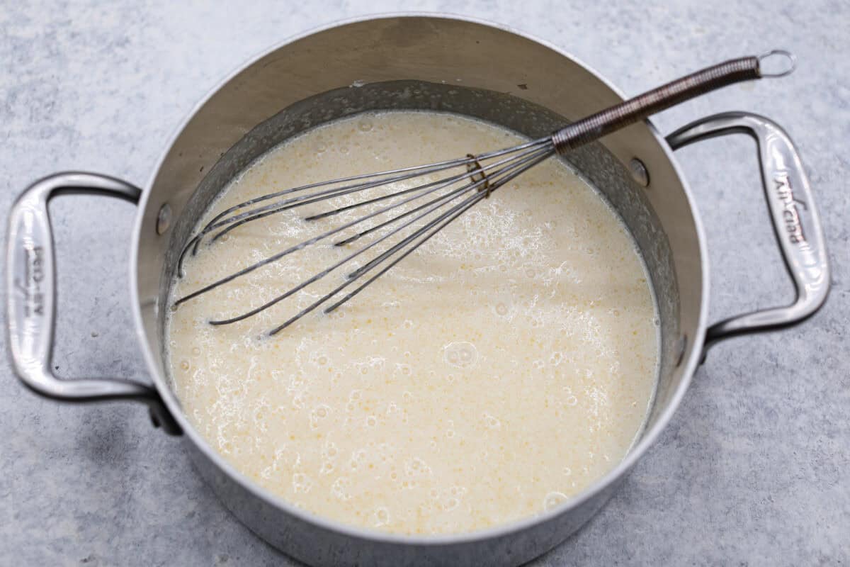 Overhead shot of pie filling ingredients in a pot with a whisk. 