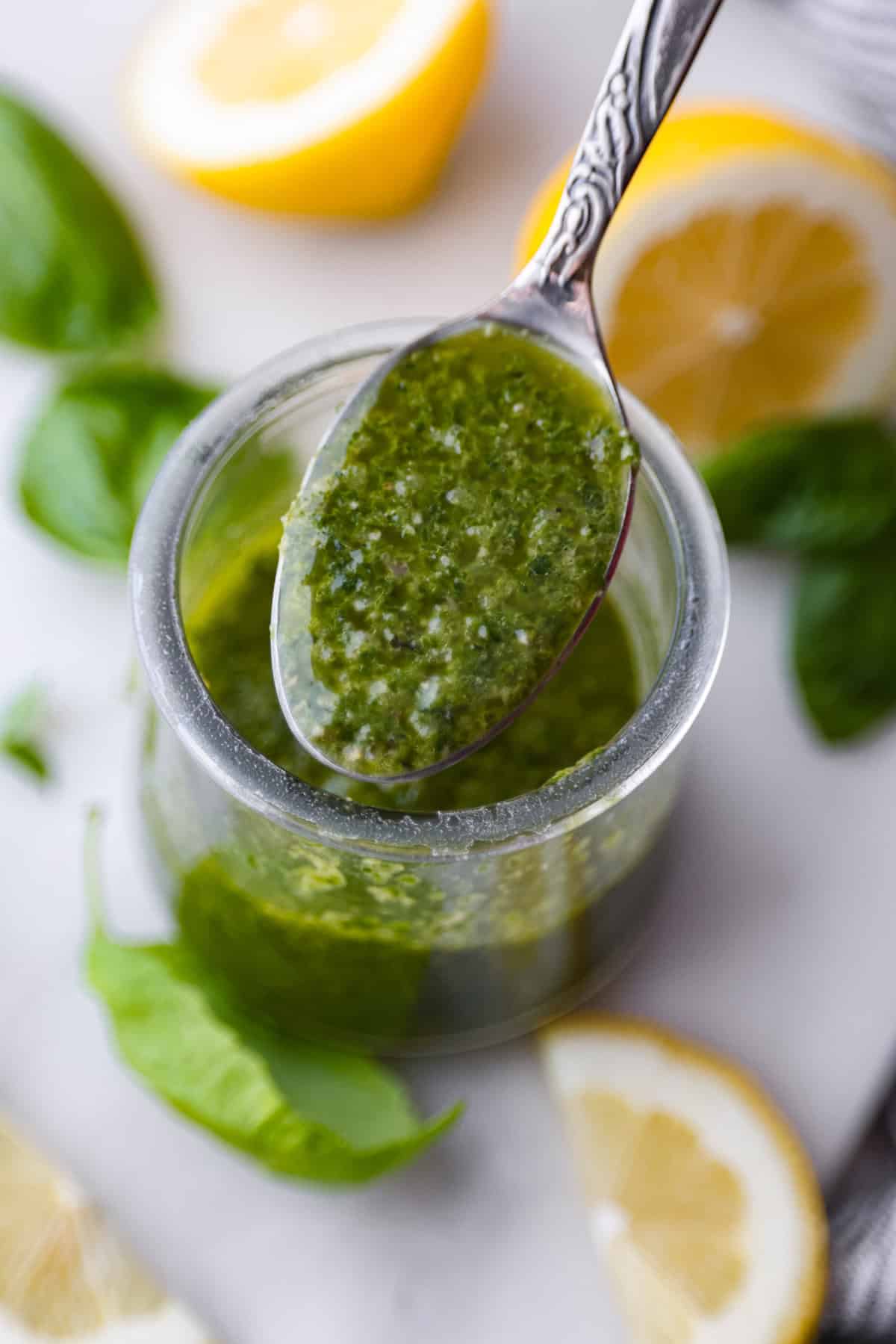 Basil Vinaigrette is a versatile dressing made from a few fresh ingredients. It is bursting with flavor and can be used on salads, as a marinade, or as a sauce for various dishes. It will be a great addition to your repertoire of homemade dressings. Close up shot of a spoonful of basil vinaigrette.
