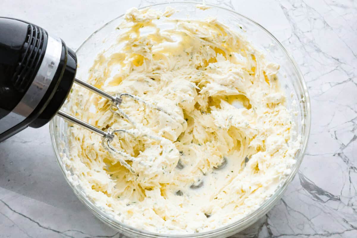 Overhead shot of a  hand mixer mixing Boursin cheese ingredients together. 