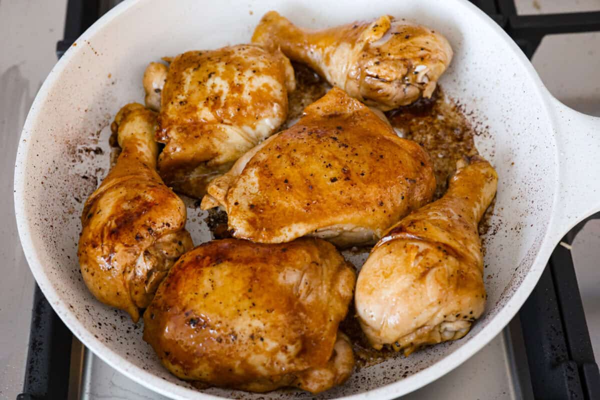 Angle shot of chicken being browned in a skillet. 